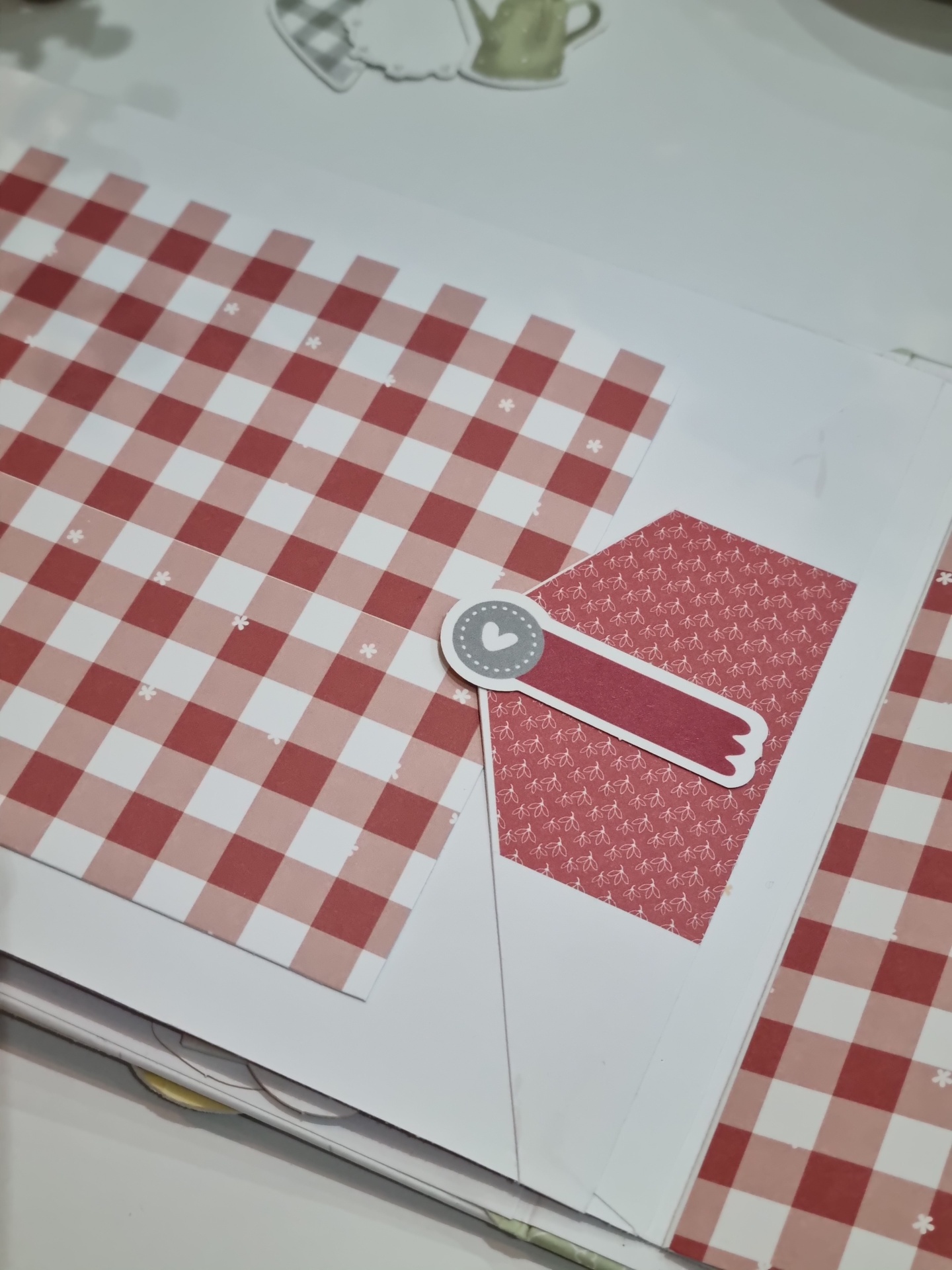 Folha com padrão xadrez vermelho e branco e etiqueta decorativa em forma de seta e círculo com coração