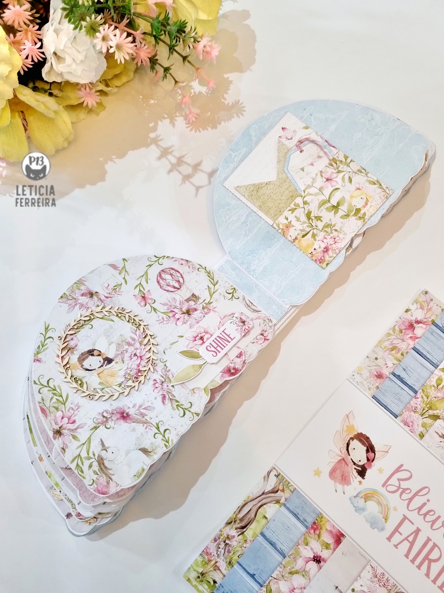 Produtos de papelaria com padrões florais e imagens de fadas em tons pastel