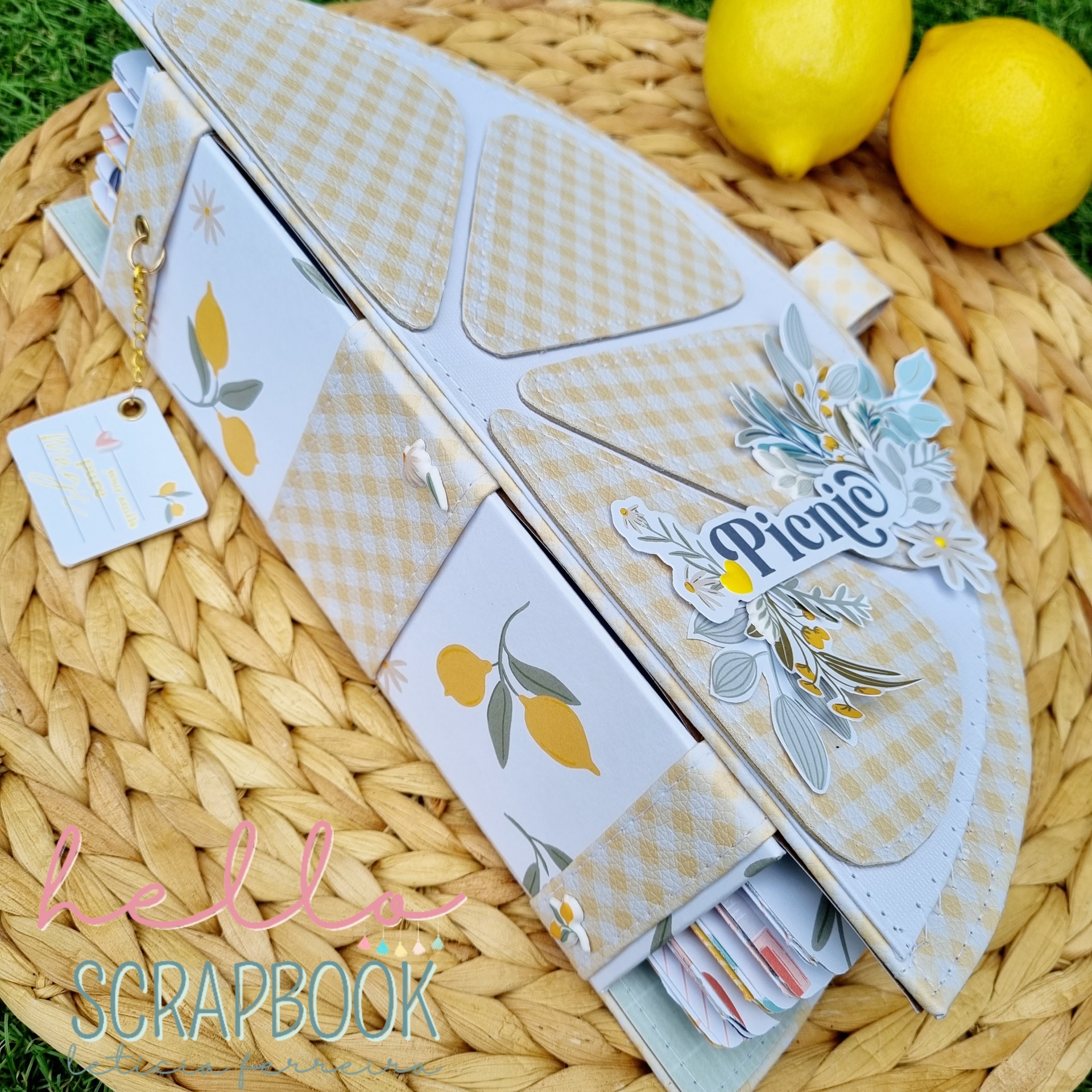 Álbum scrapbook capa dura com motivos florais e padrão xadrez bege em base trançada e limões ao fundo