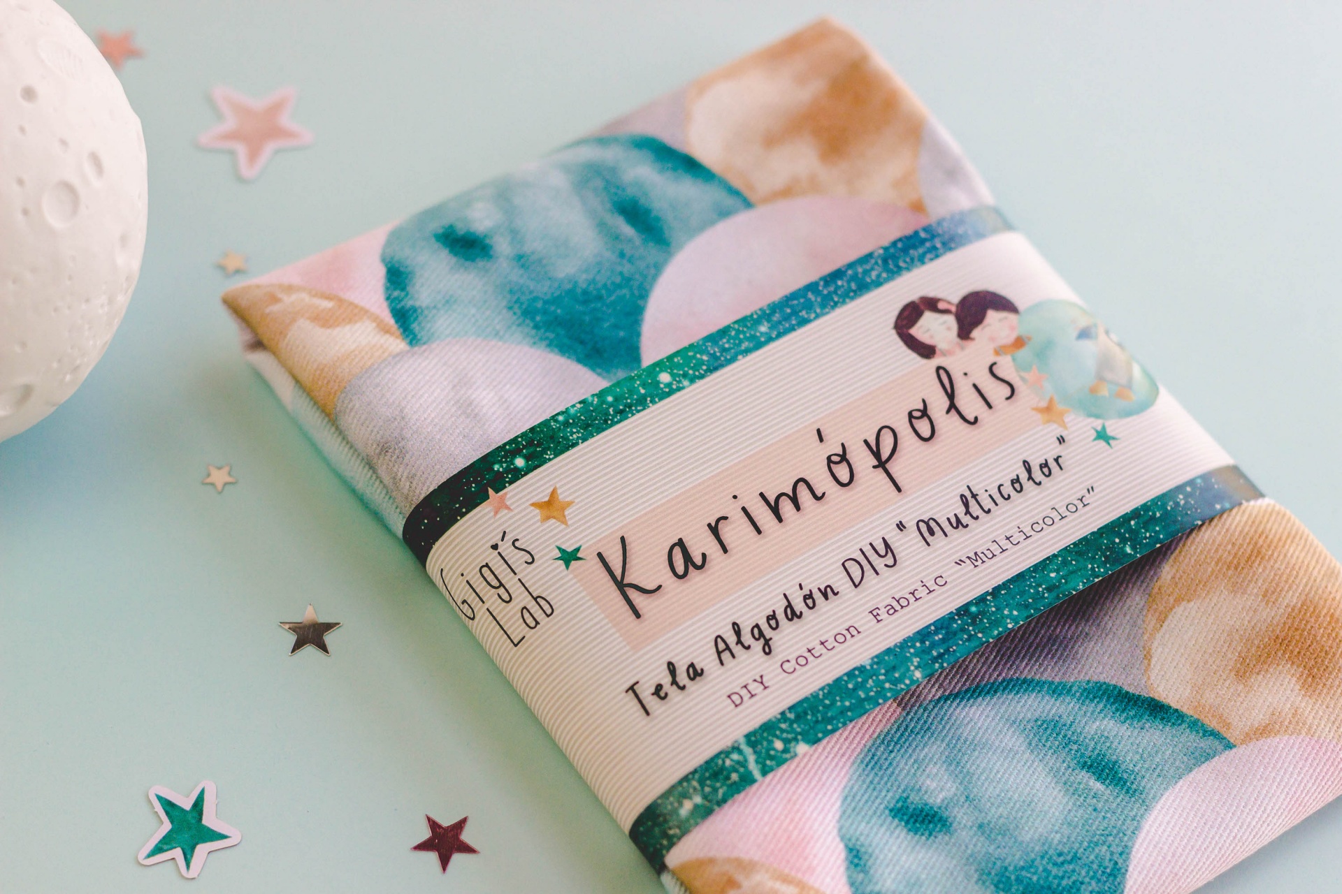 Pano de algodão com padrão de círculos azuis e bege e embalagem com texto em espanhol