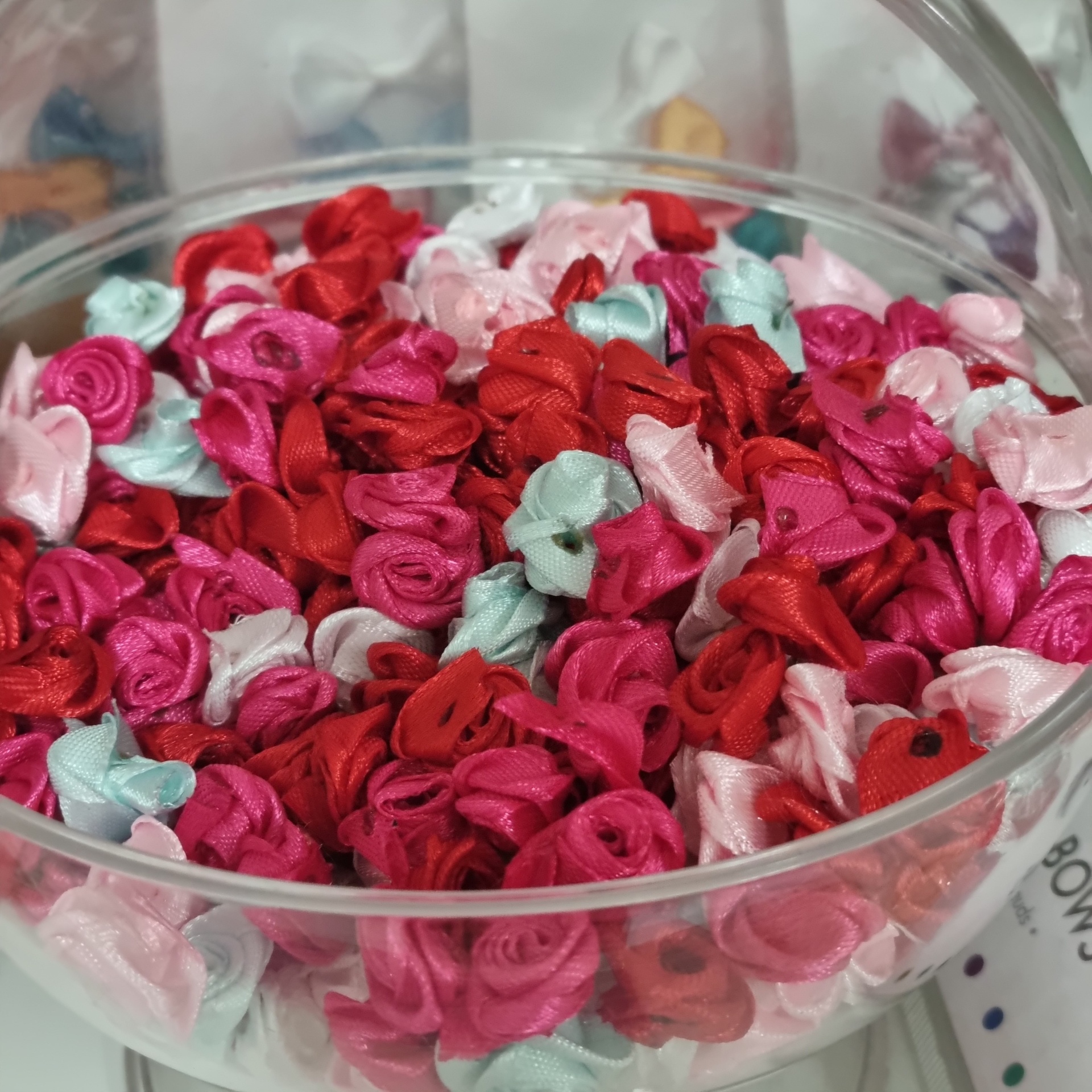 Pequenas flores de tecido coloridas em potes transparentes