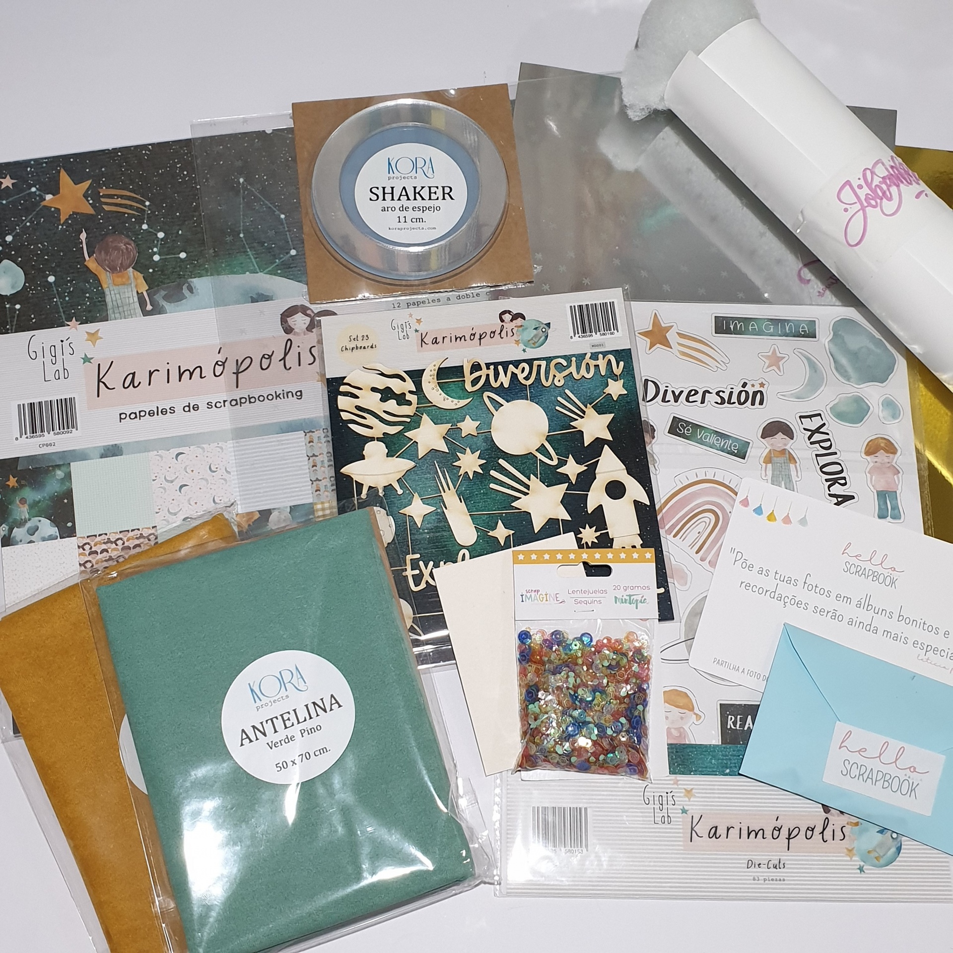Materiais de scrapbooking como tecidos, papéis e acessórios em embalagens transparentes e coloridas