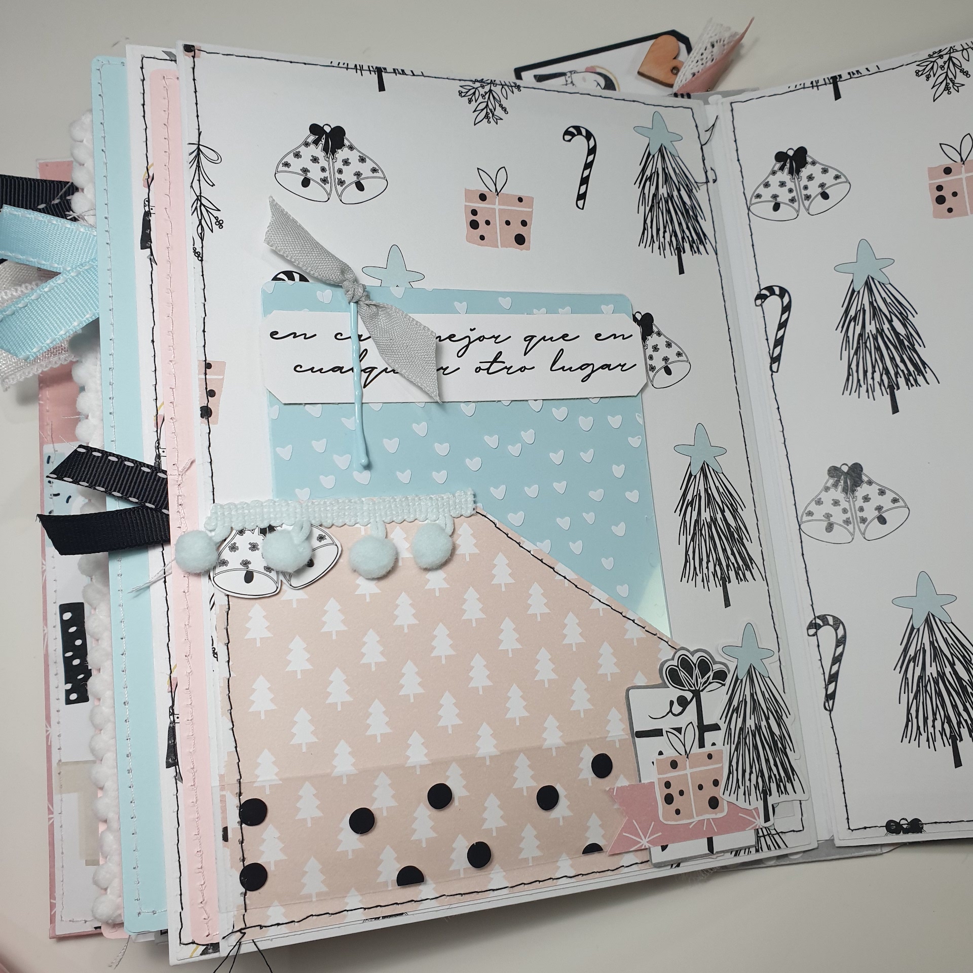 Página decorativa de álbum com padrões de Natal em azul, rosa e branco, incluindo texto em português