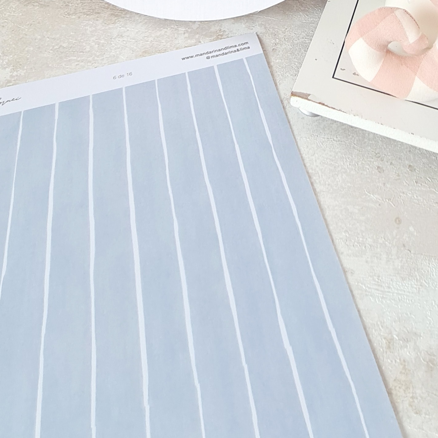 Folha riscada azul com texto no topo e objeto cor de rosa ao lado sobre superfície cinzenta