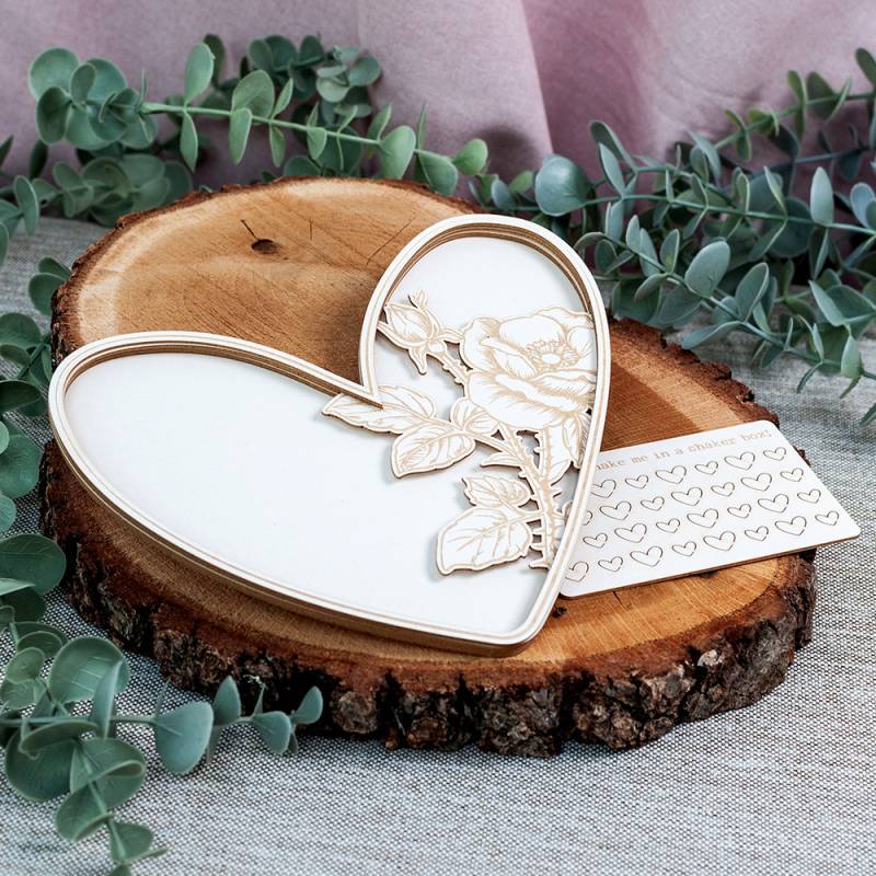 Prato decorativo em forma de coração sobre madeira e folhas verdes