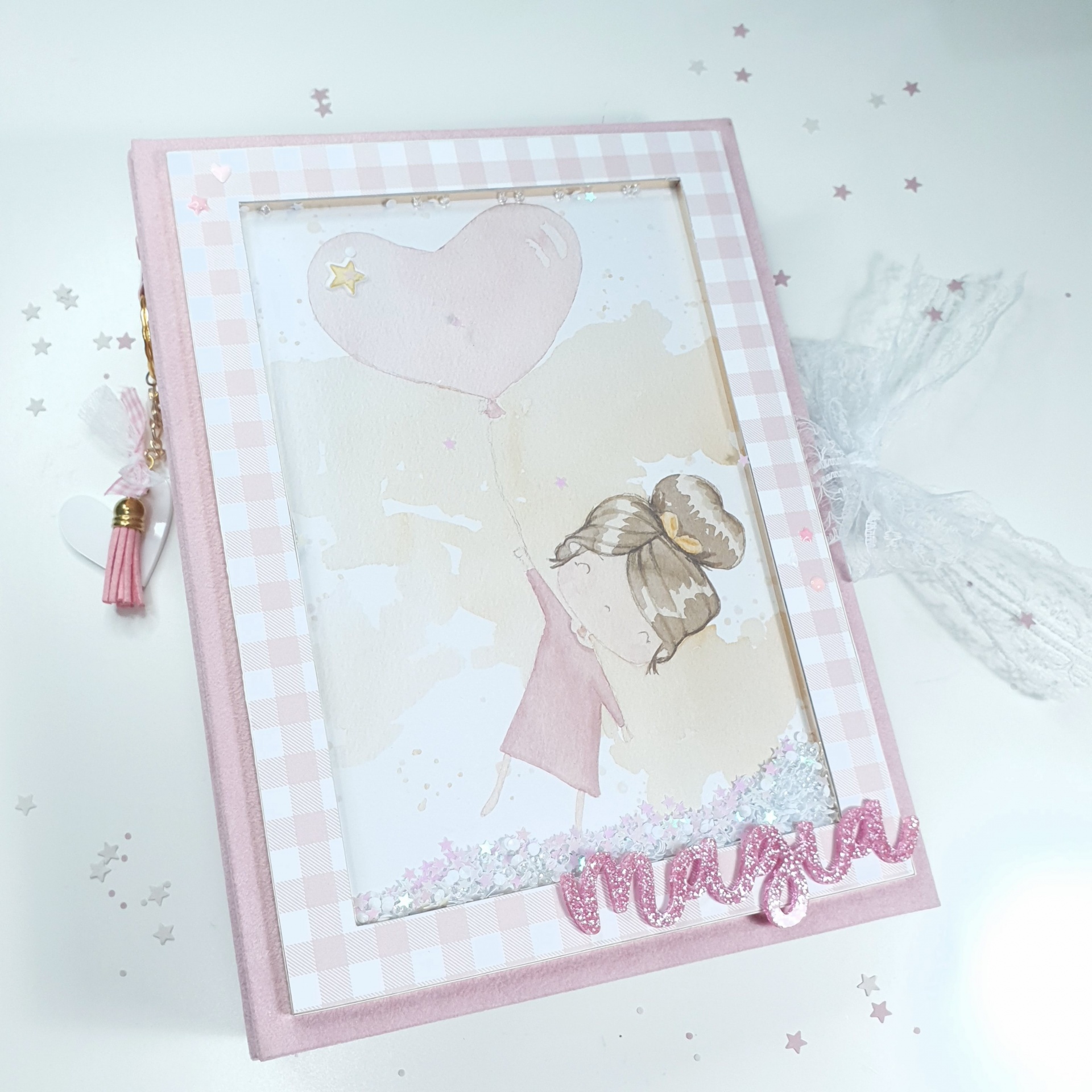 Caderno rosa com capa ilustrada de menina e balão em forma de coração e nome 'marina'