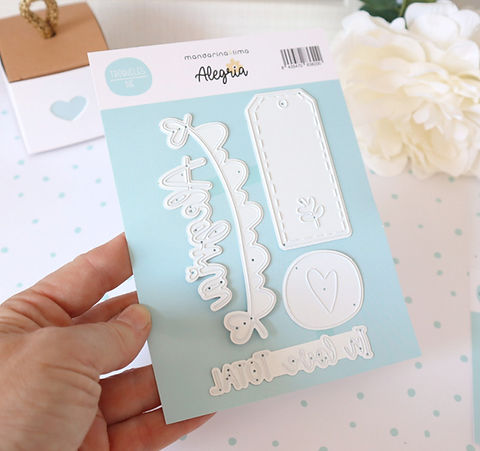 Conjunto de moldes de corte para artesanato em metal branco numa base azul claro