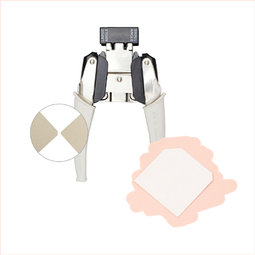 Alicate prendedor metálico com alças brancas e pedaços de material adesivo quadrado