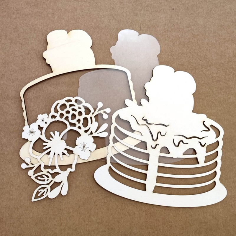 Recortes decorativos em papel branco com formas de bolos sobre fundo castanho