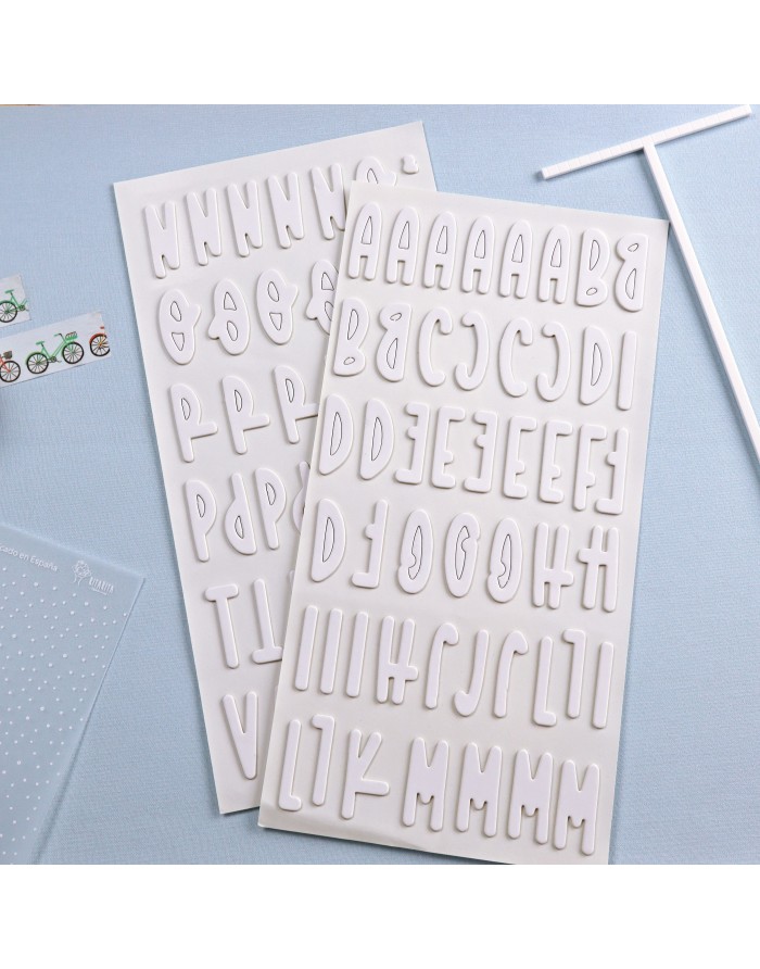 Letras adesivas em relevo brancas em tabuleiros sobre fundo azul claro