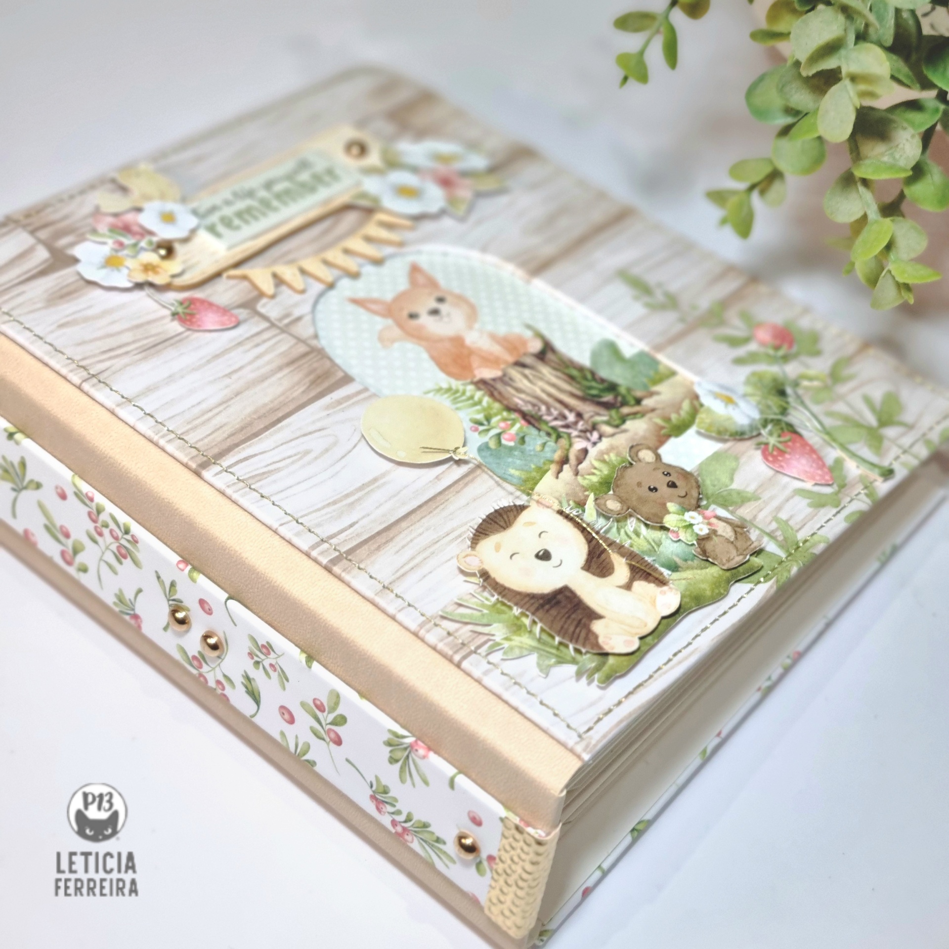Álbum scrapbook decorado com padrão de madeira, animais e flores em tons pastel