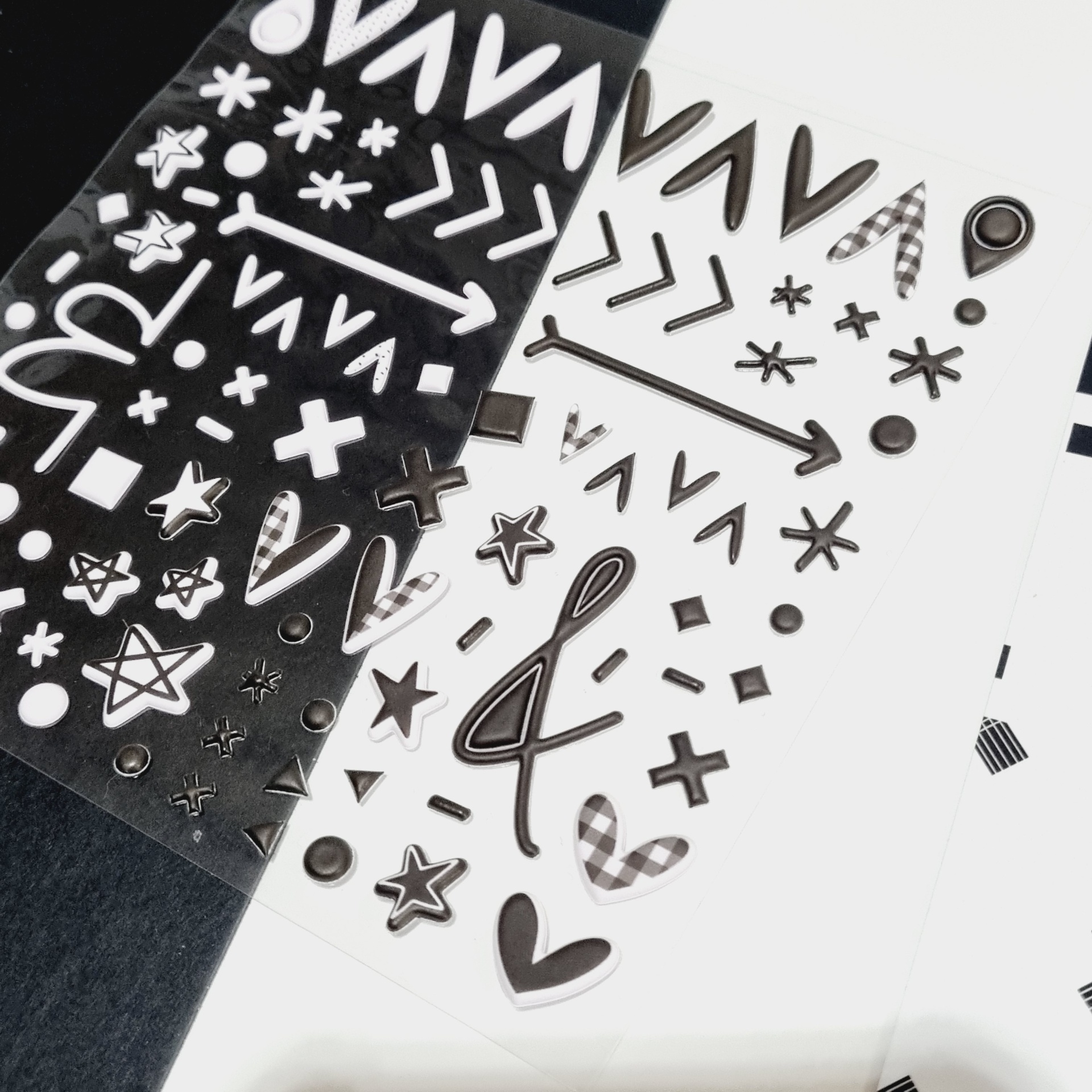 Conjuntos de autocolantes preto e branco com símbolos variados sobre fundo claro e escuro