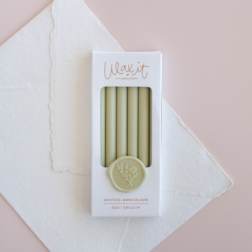 Conjunto de 6 bastões de lacre verdes numa caixa branca com selo floral