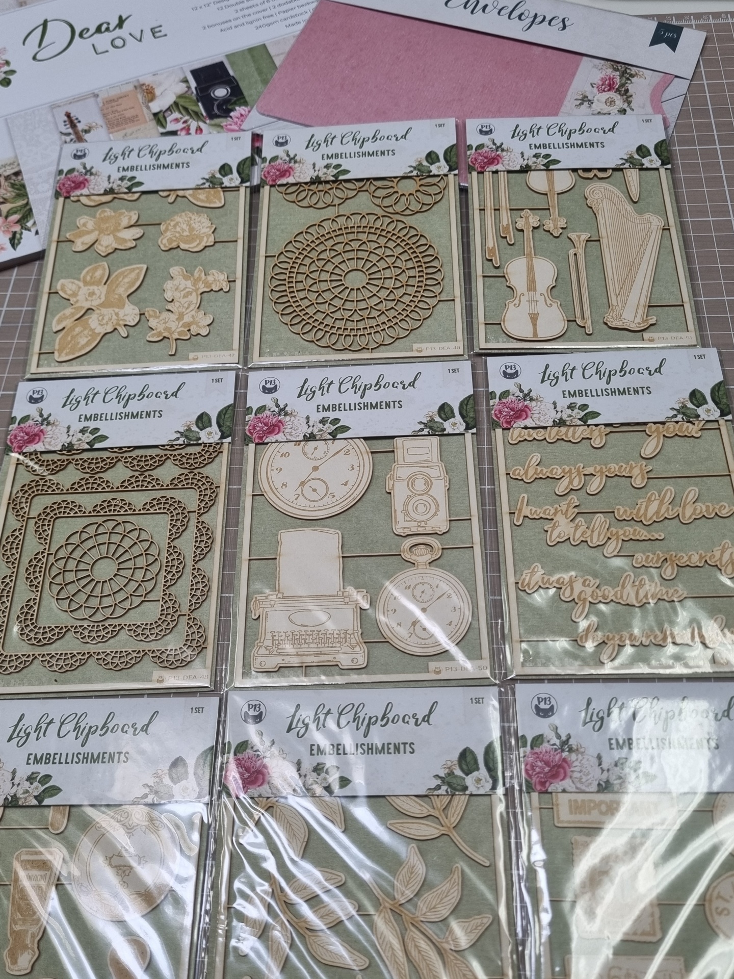Adornos chipboard claro variados para decoração artesanal em embalagens transparentes