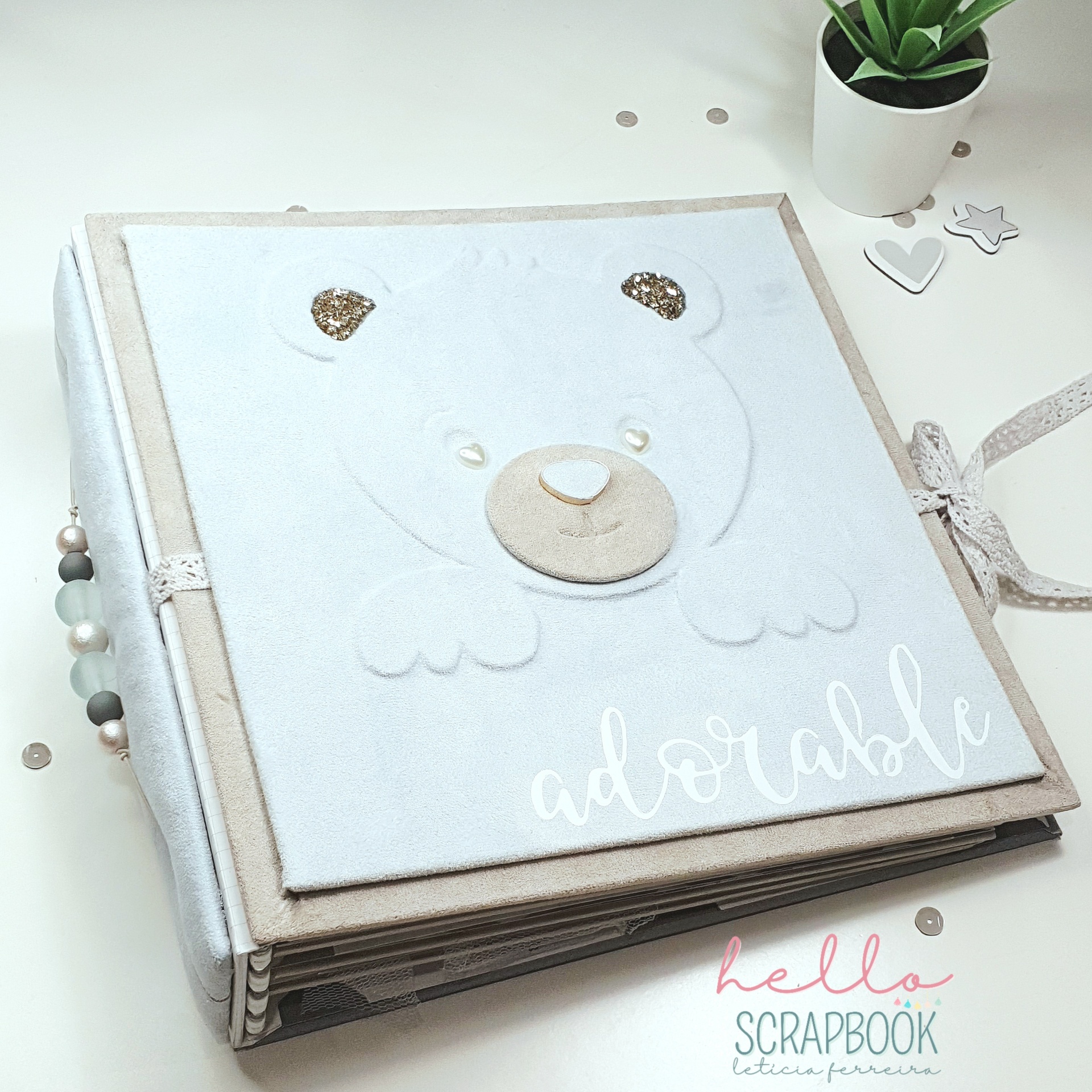 Álbum de scrapbook com capa branca com urso bordado e detalhes brilhantes