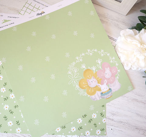 Papel de embrulho verde claro com desenhos de flores e coelhinhos em fundo branco