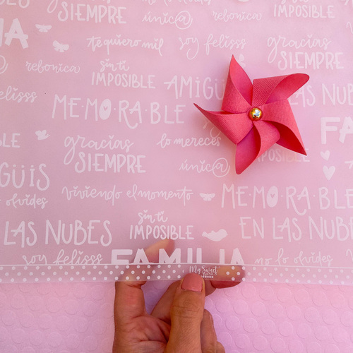 Saco rosa transparente com texto branco e pinwheel vermelho ao lado