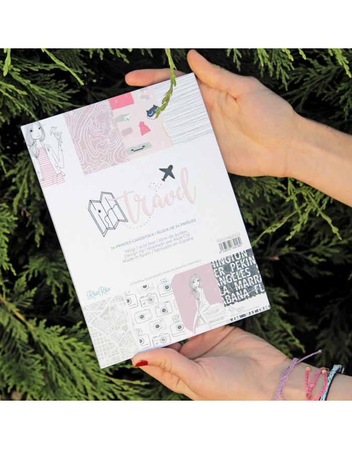 Caderno de viagem com capa decorada em tons pastel segurado por mãos femininas