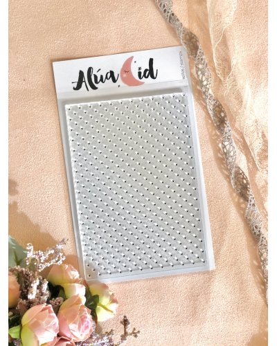 Pack de pedras autocolantes prateadas em embalagem Alúa Cid com flores e tecido ao fundo