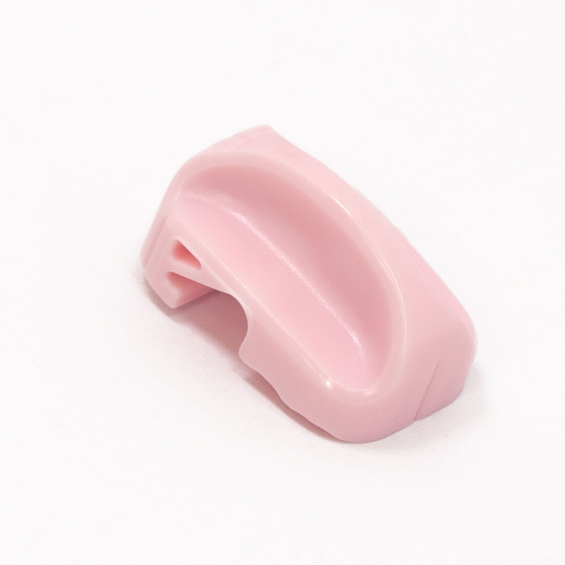 Peça plástica cor-de-rosa com forma arredondada e cavidade