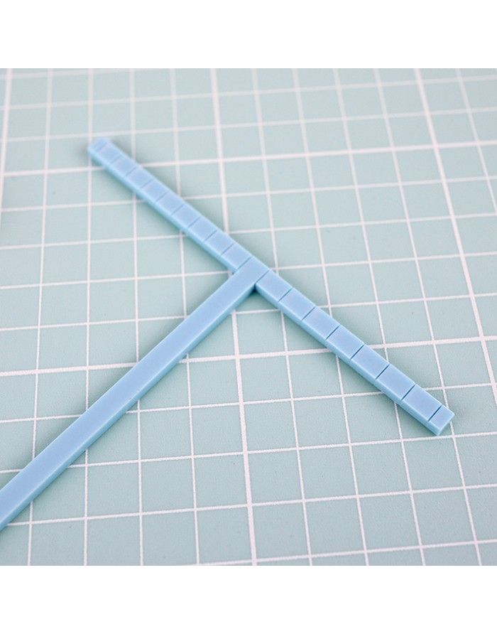 Gabarito azul em forma de T sobre fundo quadriculado verde.