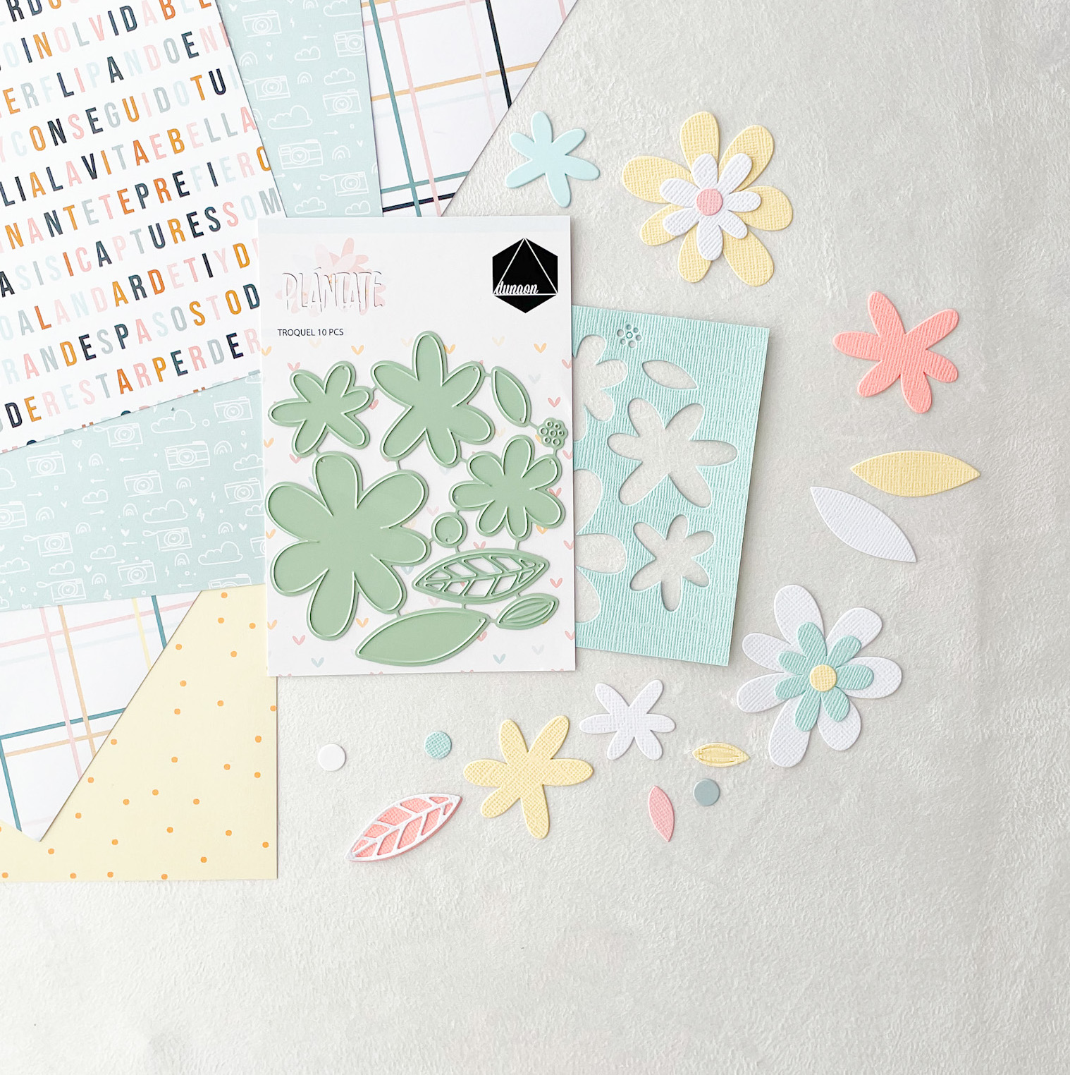 Recortes de papel em forma de flores e folhas com molde metálico em tons pastel