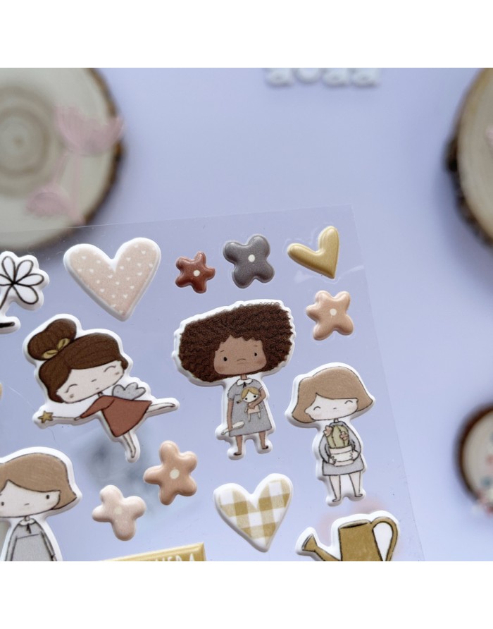 Autocolantes com desenhos de raparigas cartoon, corações e flores em várias cores sobre cartolina translúcida.