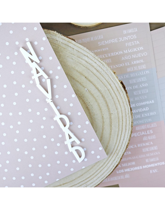 Cartão cor-de-rosa com bolinhas brancas e letras NAÍPAD sobre madeira clara