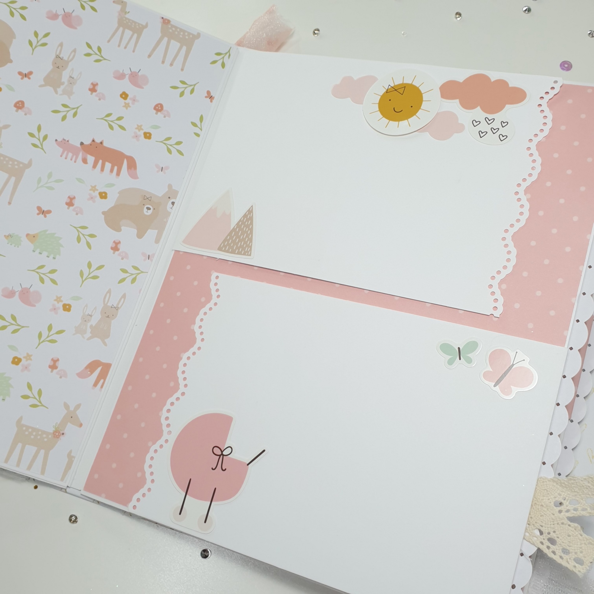 Caderno ou álbum aberto com páginas decoradas infantis em rosa e branco