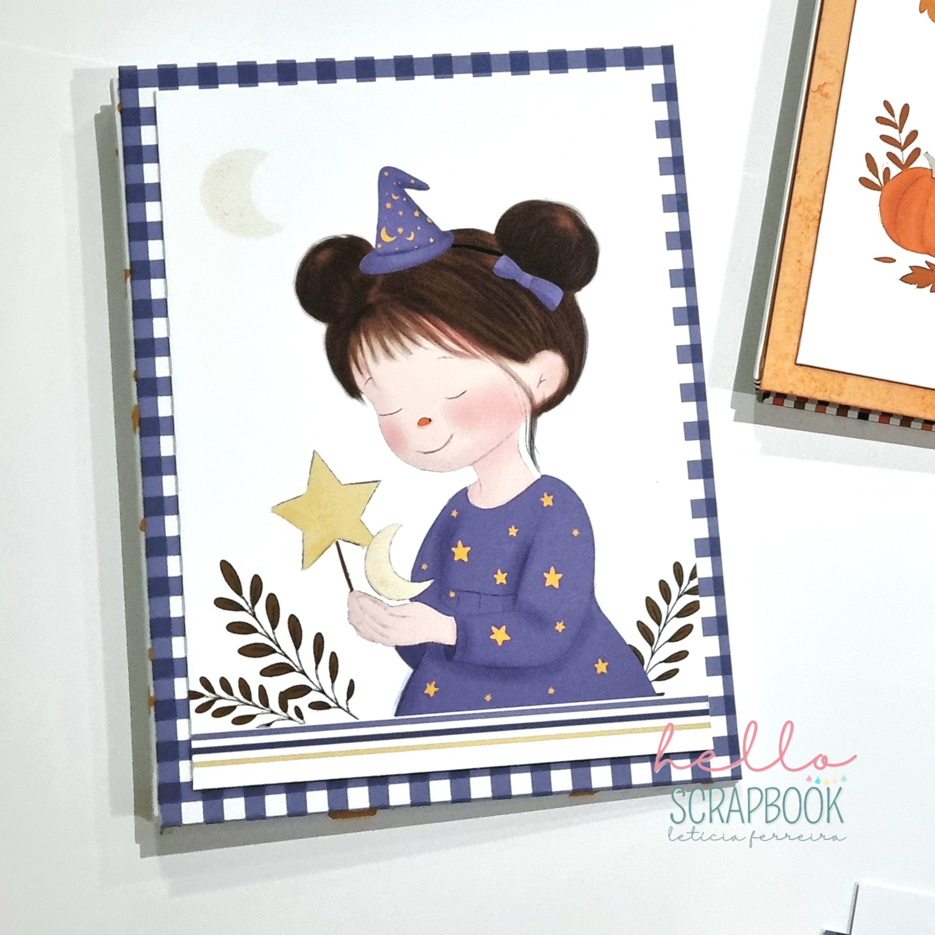 Capa de álbum scrapbook com ilustração de menina vestindo vestido azul com estrelas amarelas e chapéu de bruxa