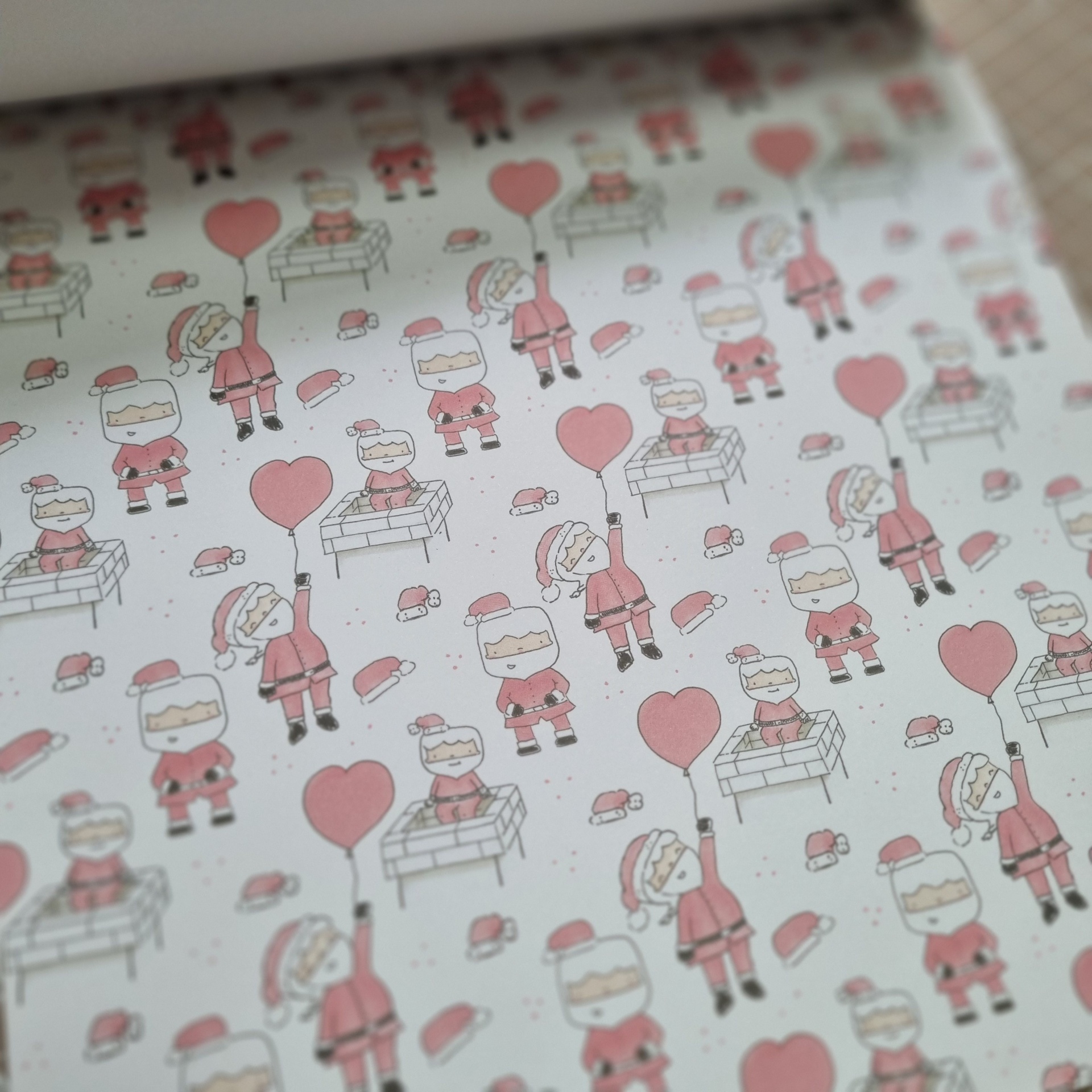 Papel de embrulho com desenhos de Pai Natal e balões cor de rosa