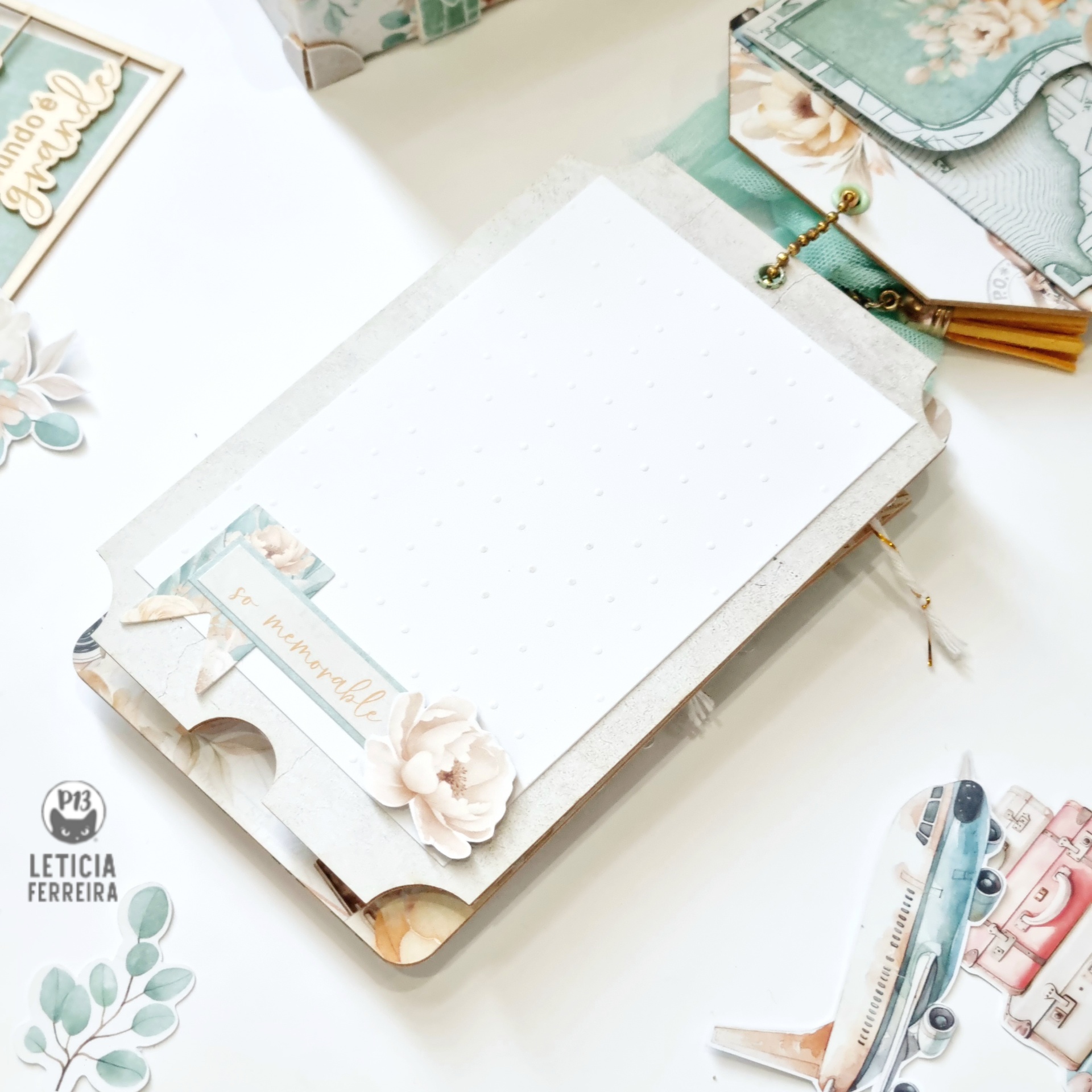 Planner aberto com folhas pontilhadas e decoração floral em mesa com papelaria decorativa em tons pastel
