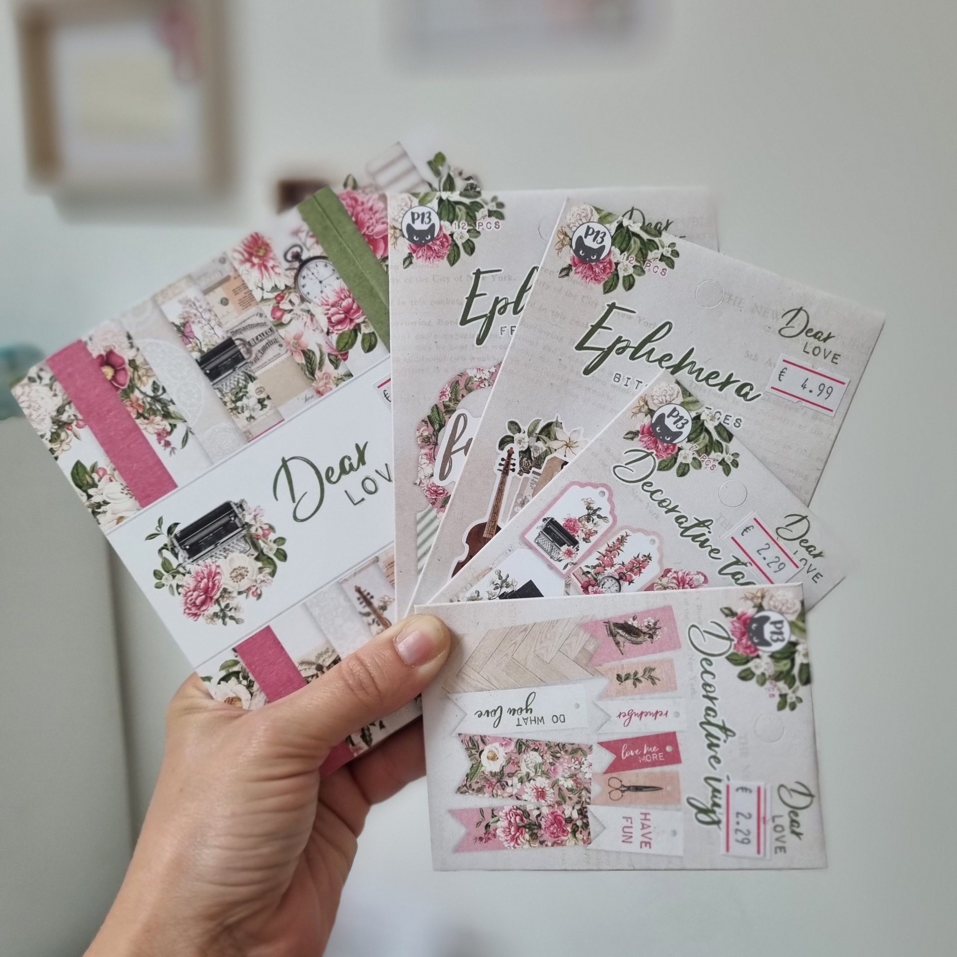 Conjunto de papéis decorativos com padrões florais e etiquetas, embalagens com preços em euros.