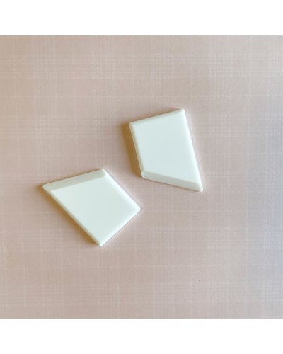 Dois objetos brancos geométricos sobre superfície cor de rosa com padrão