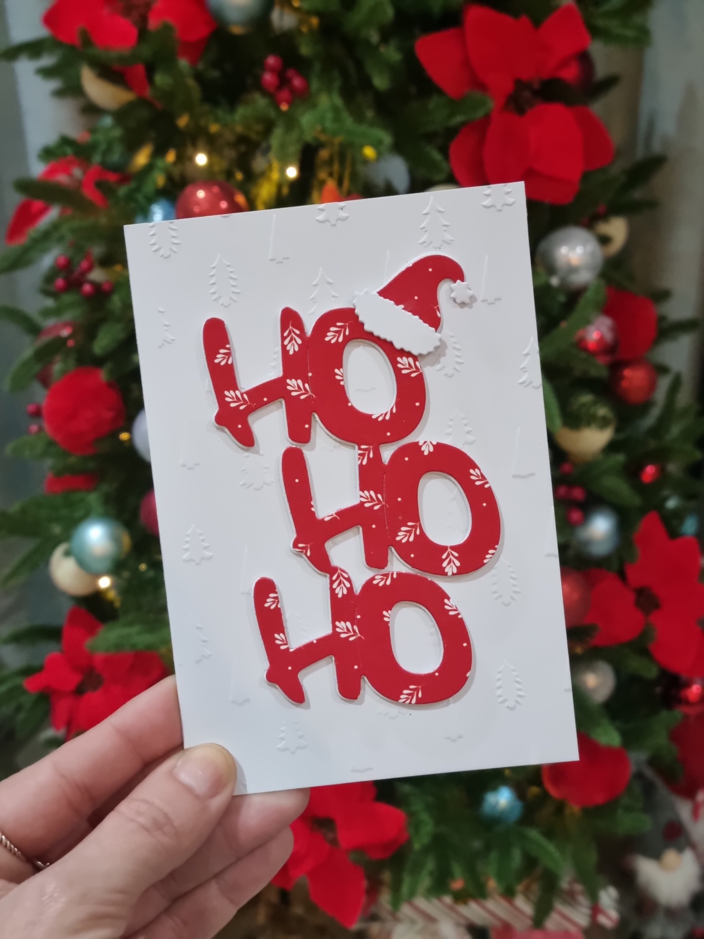 Cartão de Natal branco com texto HO HO HO em vermelho e relevo