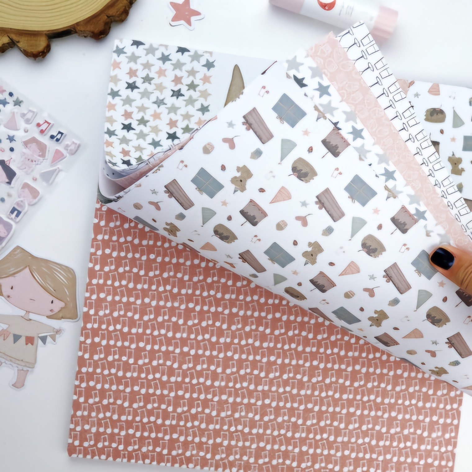 Papel decorativo com padrões de ursinhos, castelos, estrelas e notas musicais em tons pastel para scrapbook