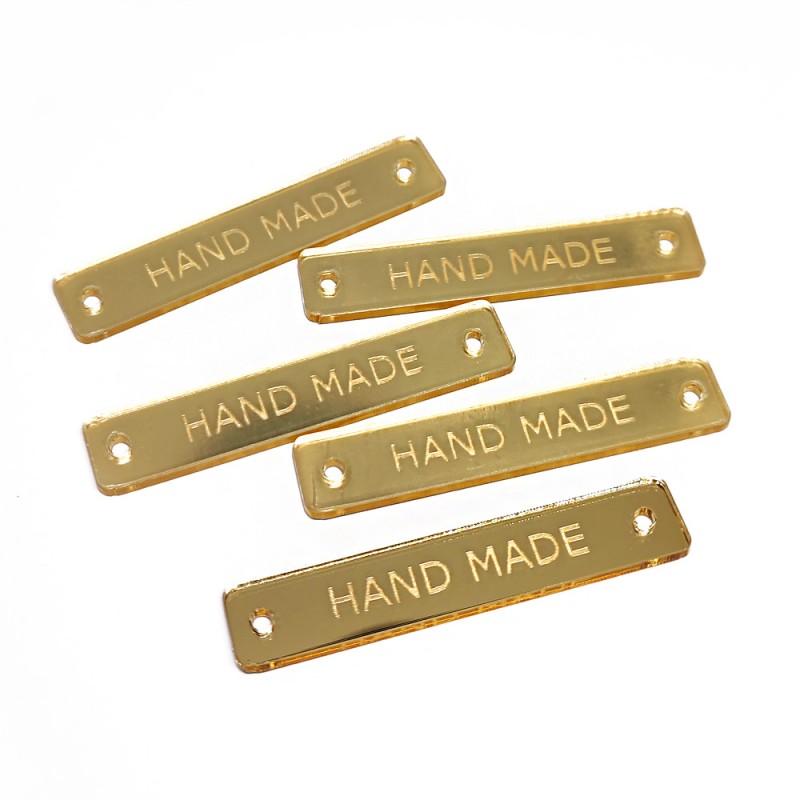 Etiquetas douradas retangulares com texto HAND MADE