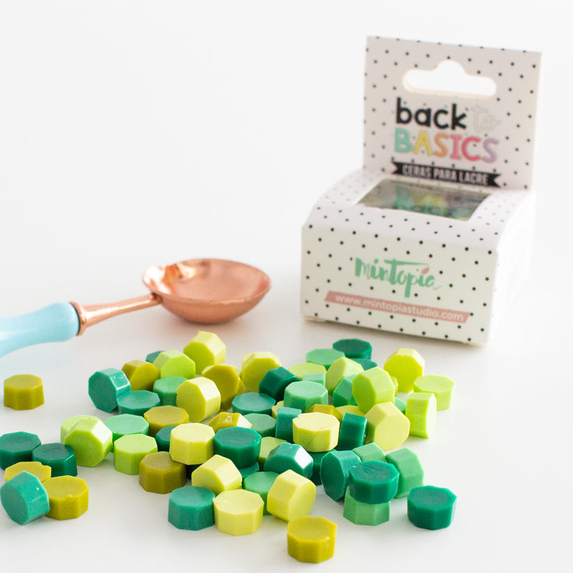 Pastilhas coloridas verdes e amarelas com colher e embalagem de utensílio para lacre