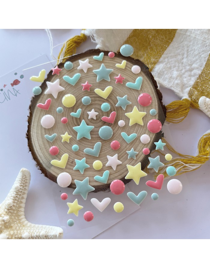 Conjunto de autocolantes estampados com estrelas e corações coloridos em tons pastel sobre madeira redonda