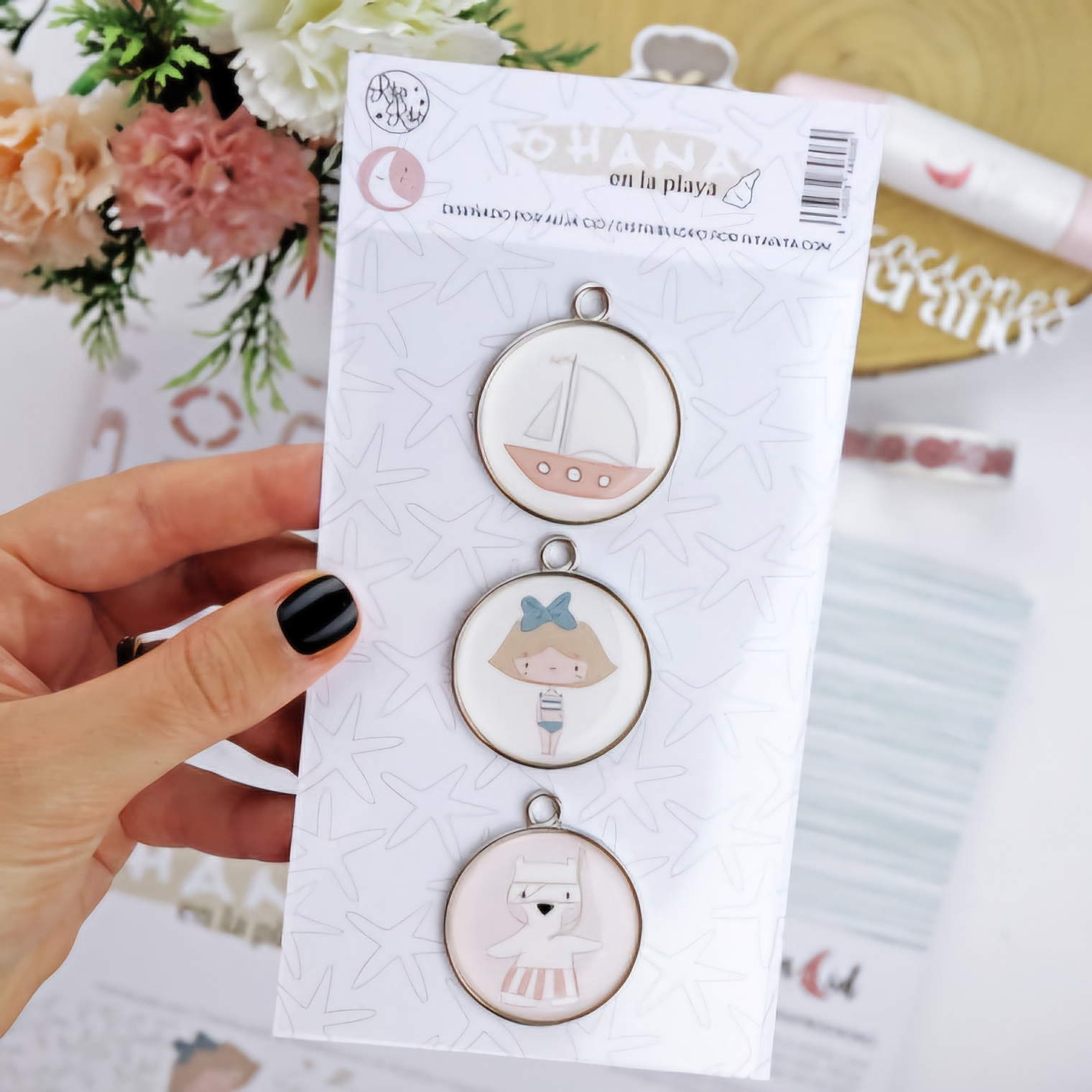 Três medalhões redondos com ilustrações infantis e embalagem branca com texto