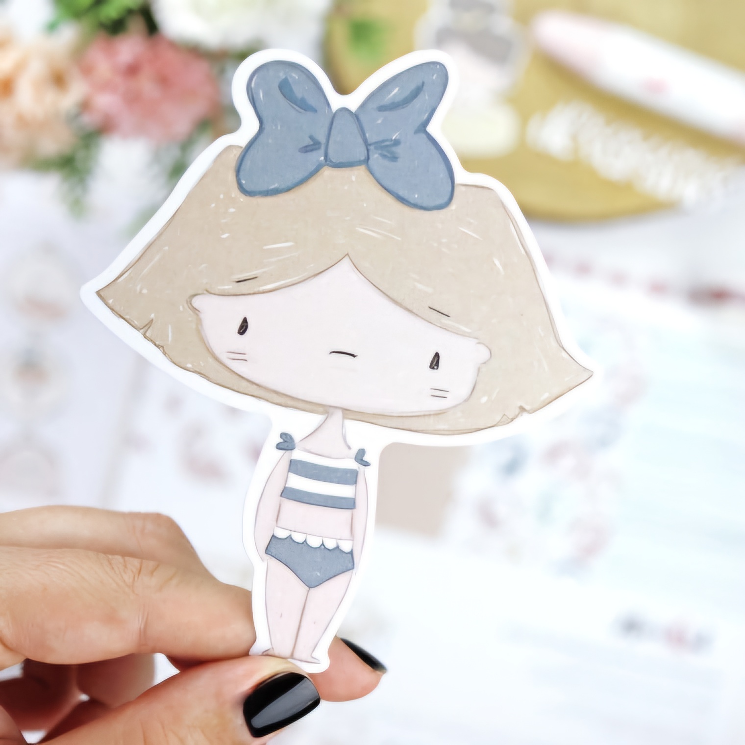 Autocolante de menina loira com laço azul e roupa de banho às riscas