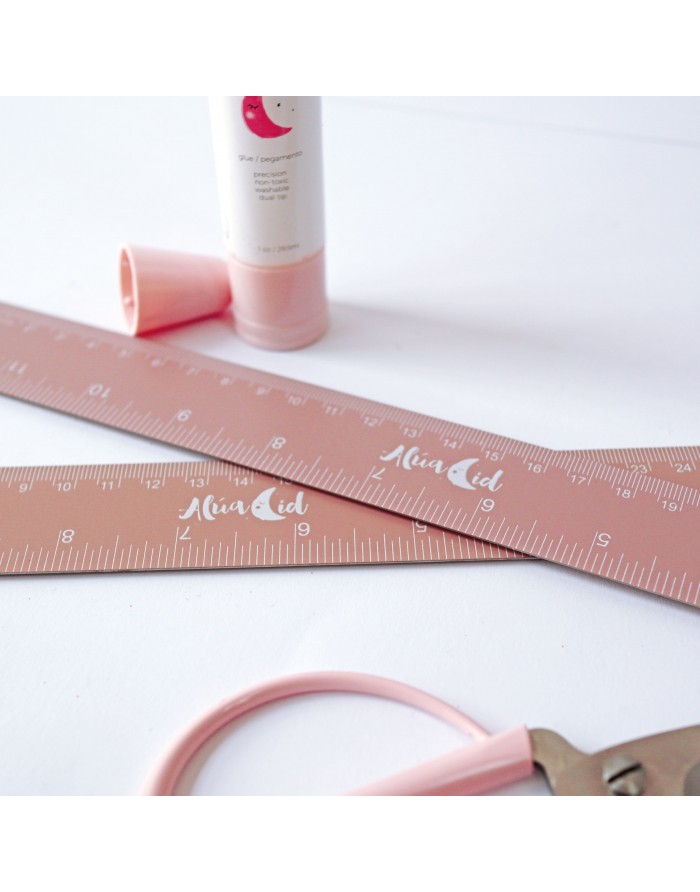 Dois réguas cor-de-rosa AlivaAid, tubo de creme cor-de-rosa e ferramenta com cabo cor-de-rosa sobre fundo branco