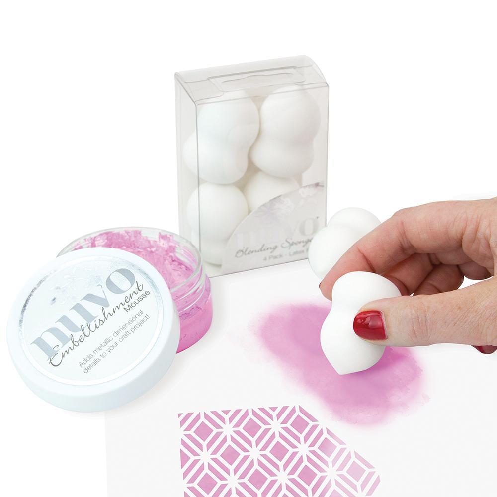 Caixa transparente com esponjas brancas e recipiente branco PIVO com pó cor de rosa e mão a aplicar.