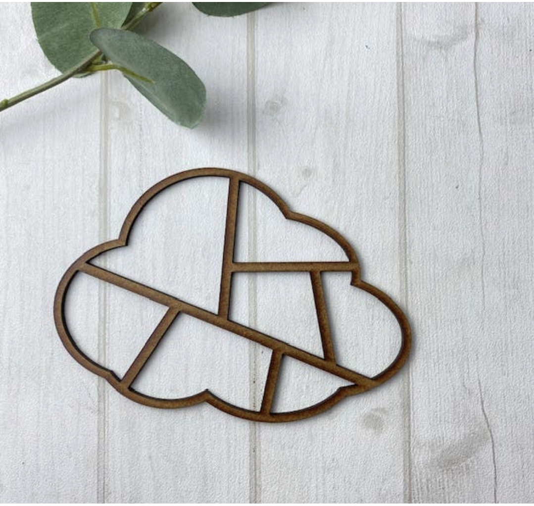 Suporte decorativo de madeira em forma de nuvem com cortes geométricos sobre superfície de madeira clara