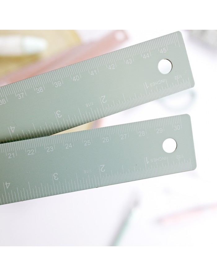 Duas réguas cinzentas com medidas em cm e polegadas sobre fundo claro