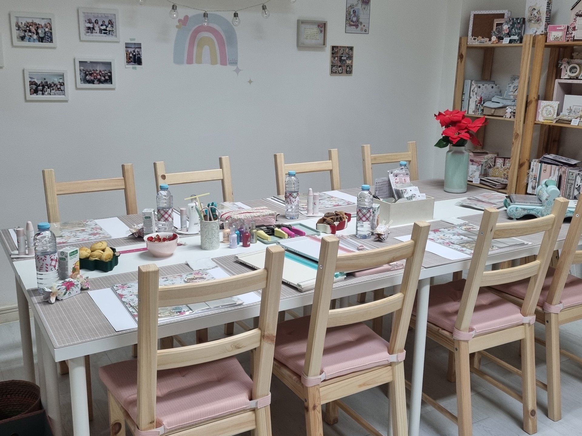 Mesa pronta para reunião com cadeiras claras e objetos diversos em cima.