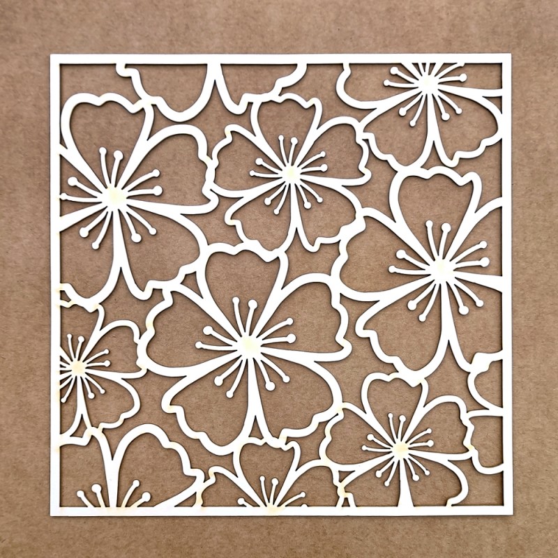 Painel decorativo branco com flores recortadas sobre fundo castanho