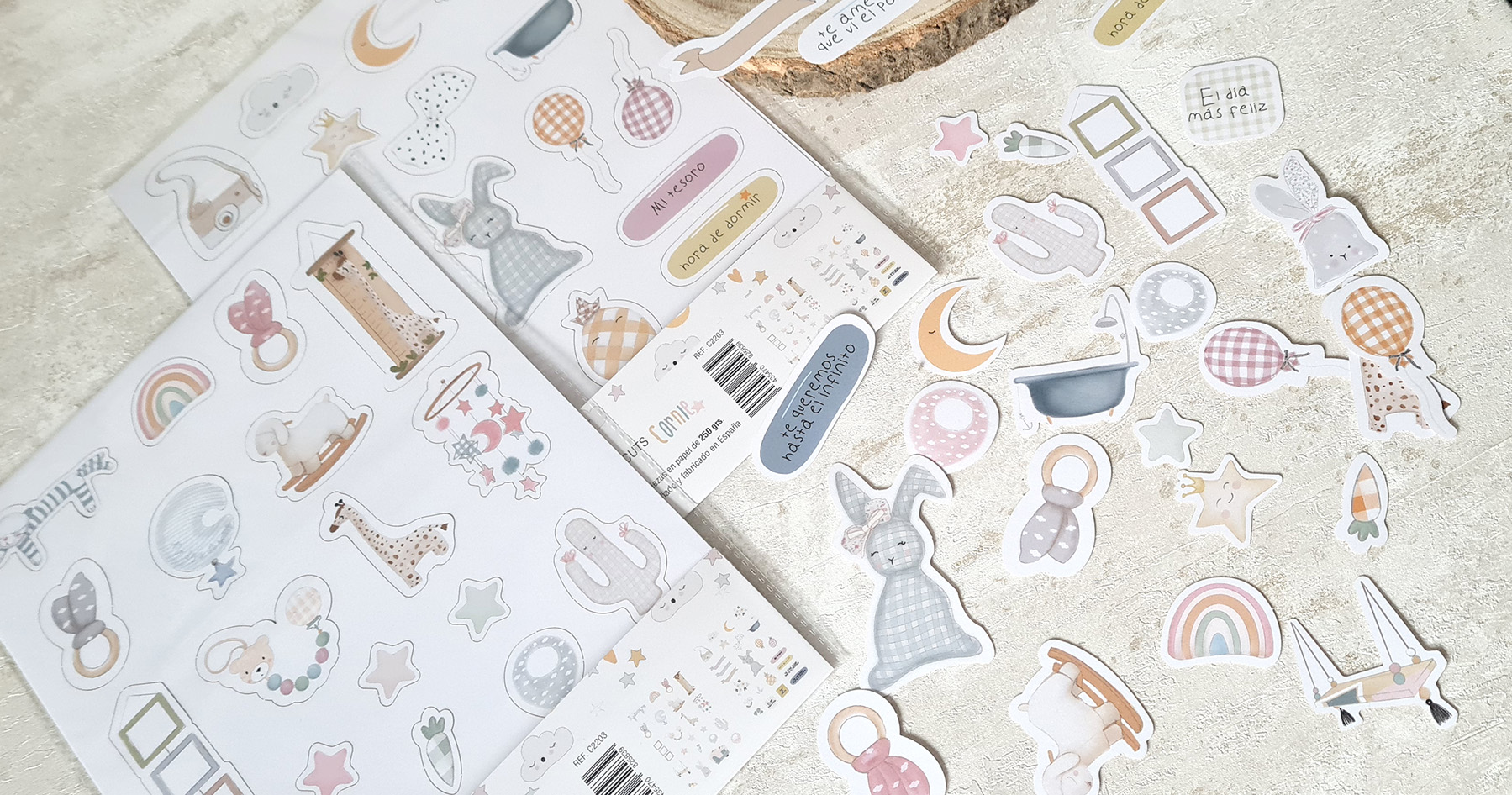 Duas folhas de autocolantes coloridos com desenhos de animais, balões e formas em tons pastel numa superfície clara