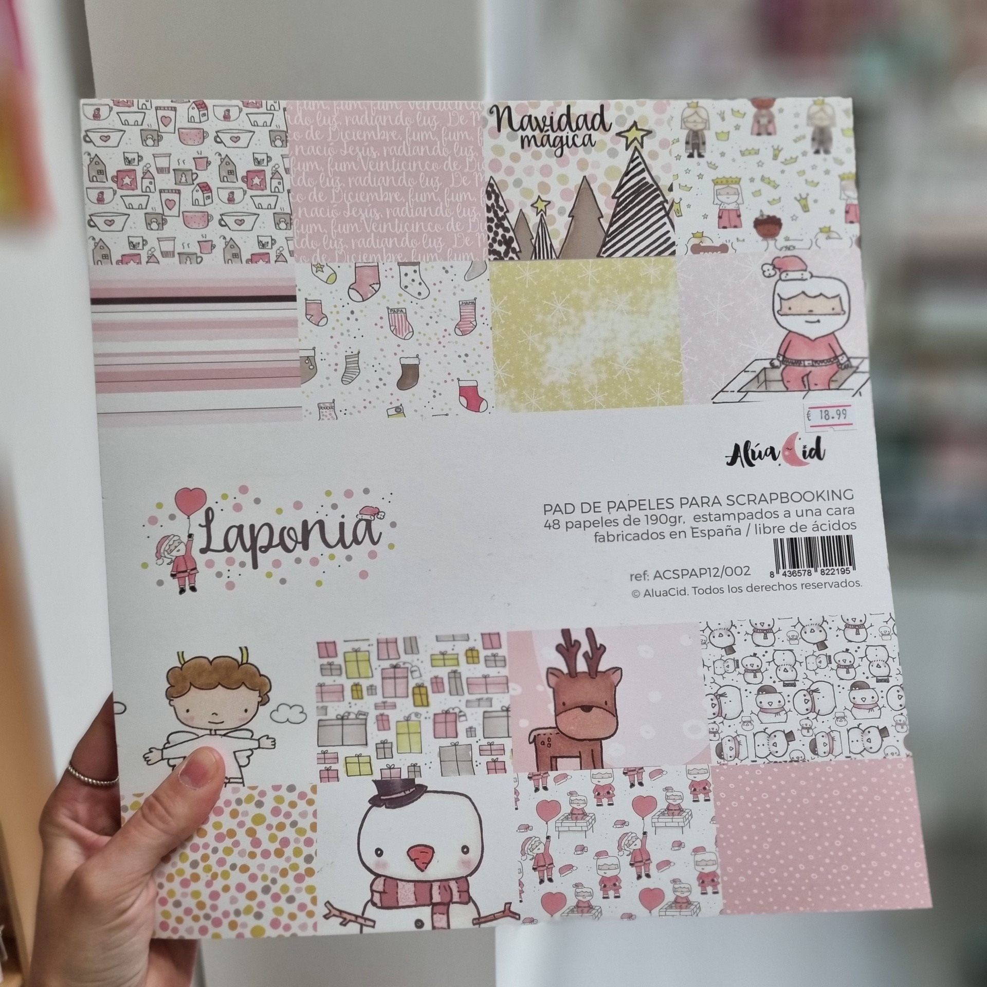 Papel para scrapbook com desenhos natalícios em tons pastel e texto em espanhol.