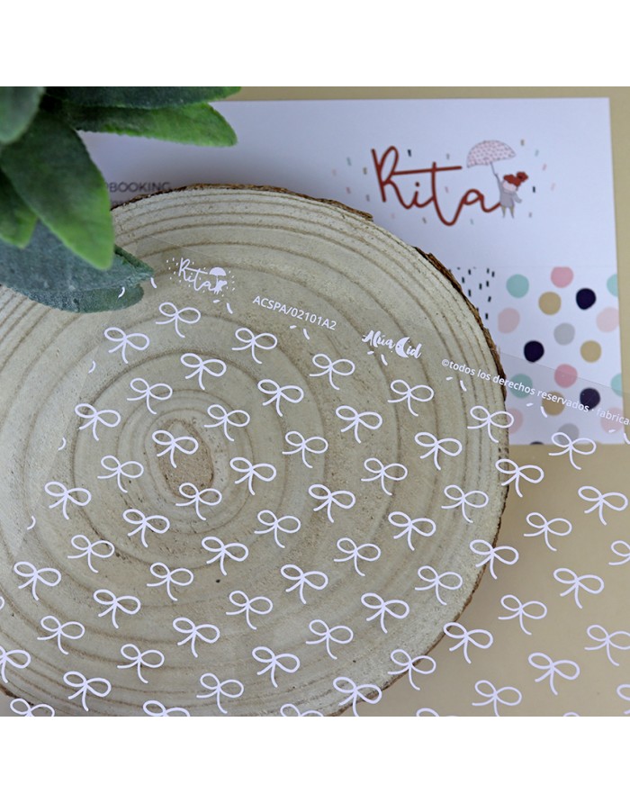 Adesivos transparentes redondos com laços brancos sobre disco de madeira e cartão Kita